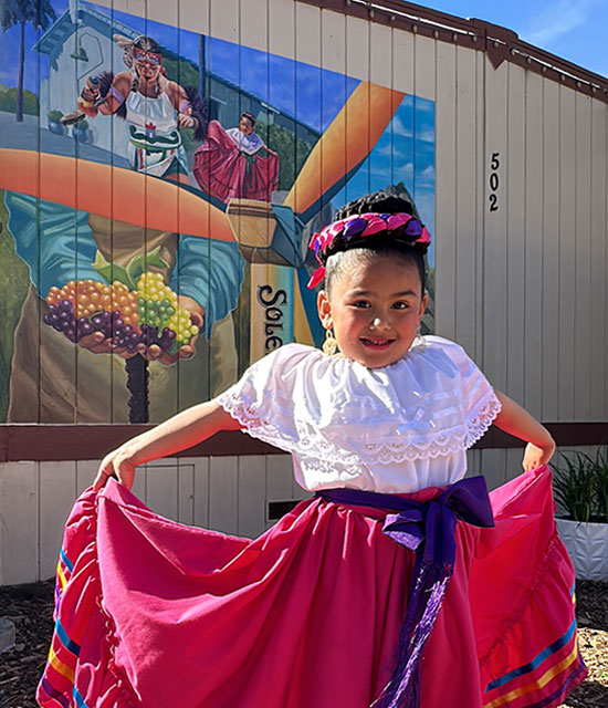 little girl in front of mural
